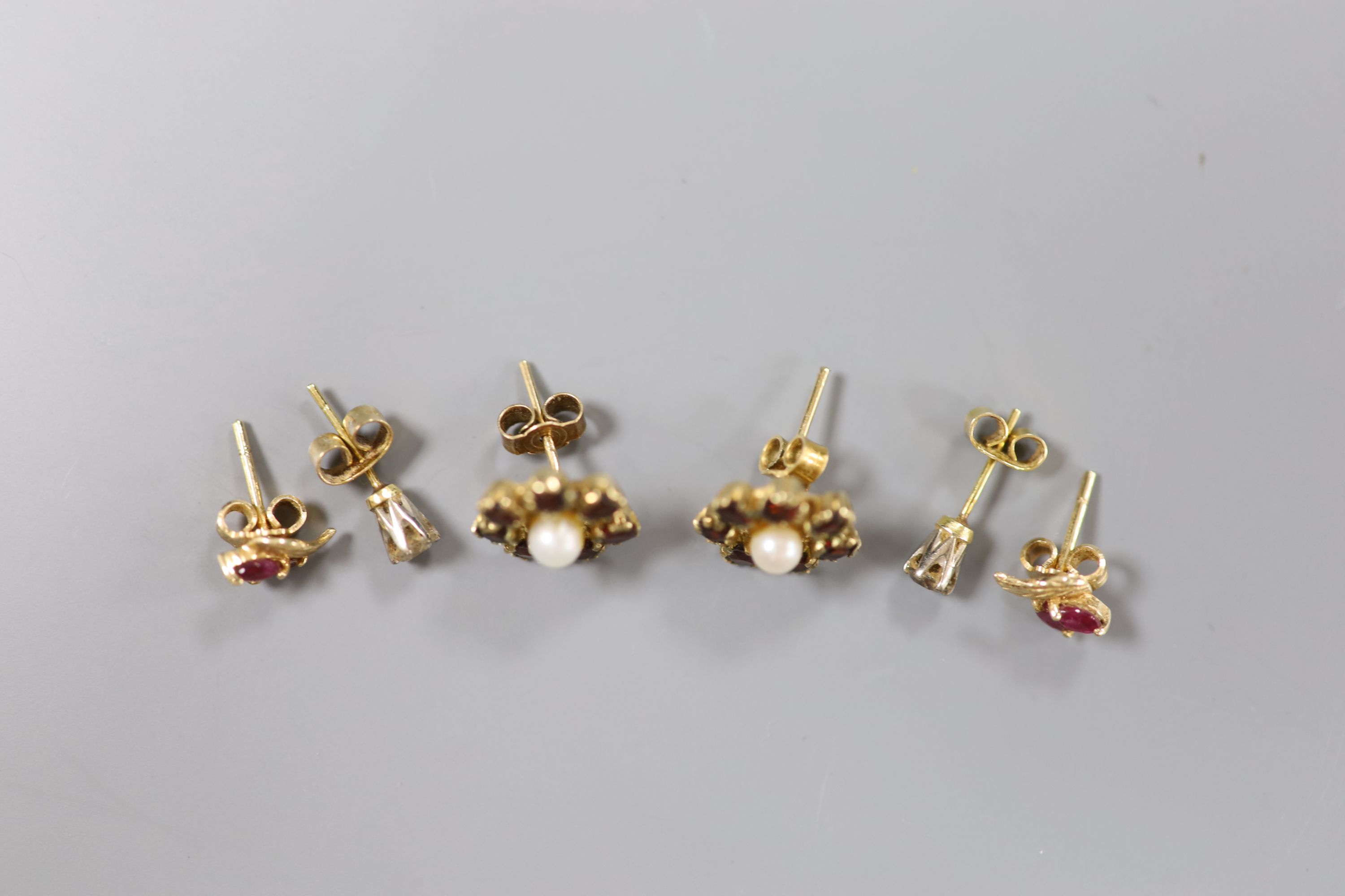 A pair of diamond stud earrings and two other pairs of stud earrings